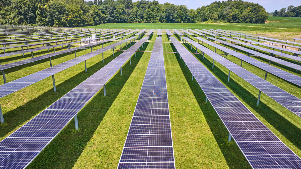 Image of Low aerial of solar farm with vertical panels on summer day in rural area of Midwest